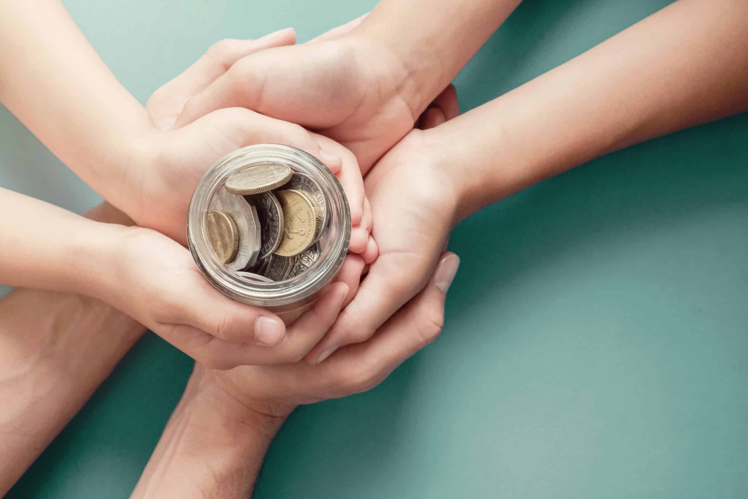 a hands holding a jar of coins